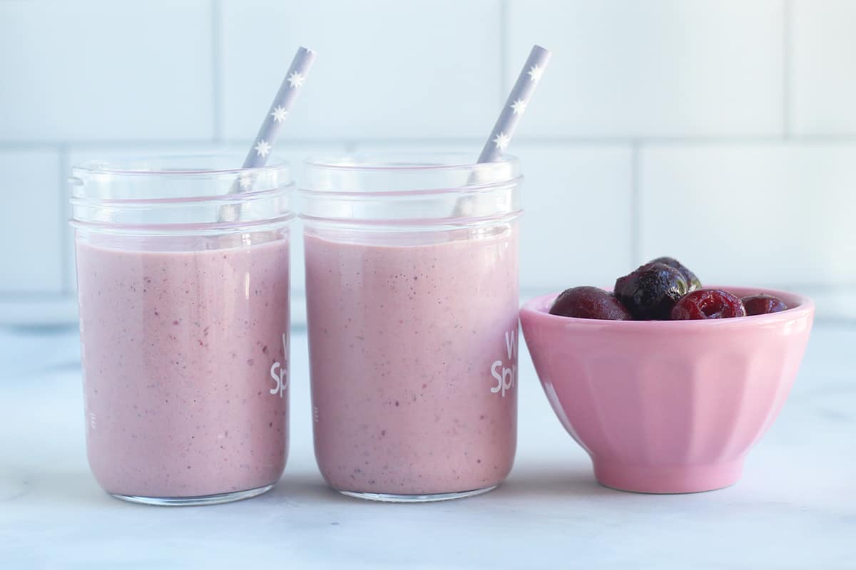 cherry smoothie in jars with straws