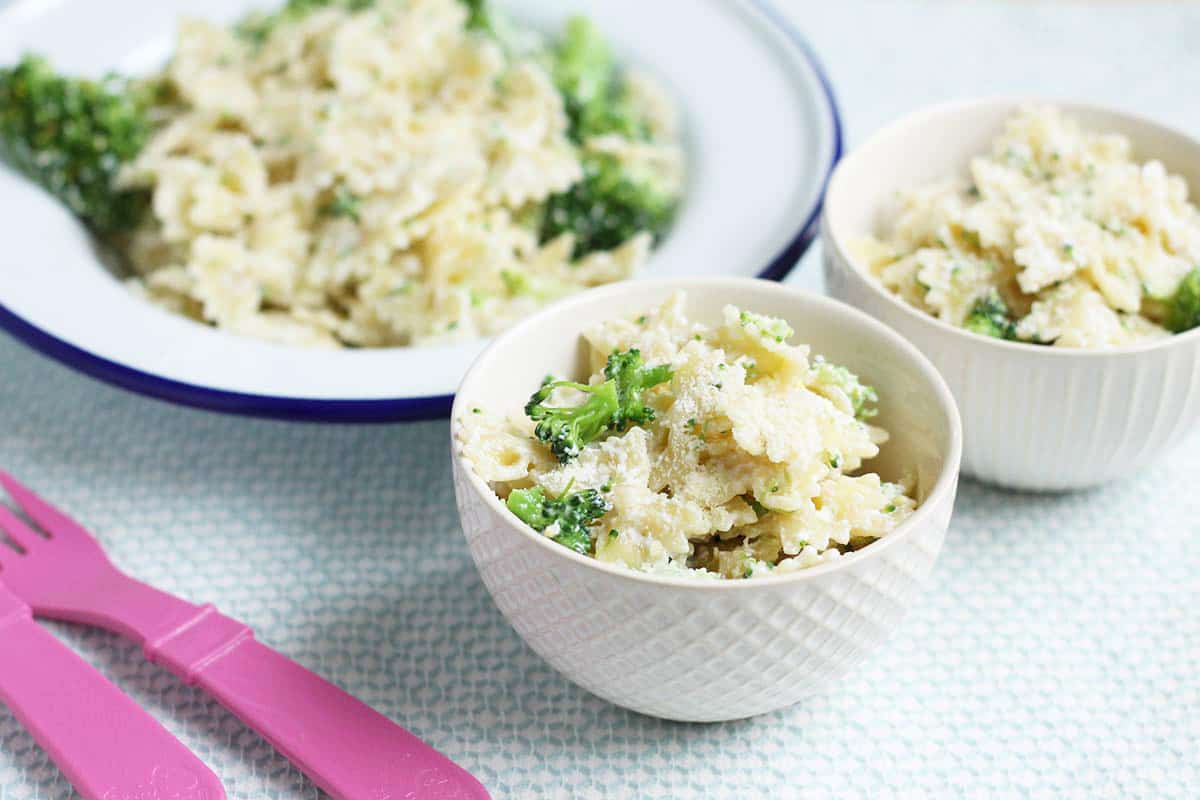 creamy broccoli pasta in white bowls