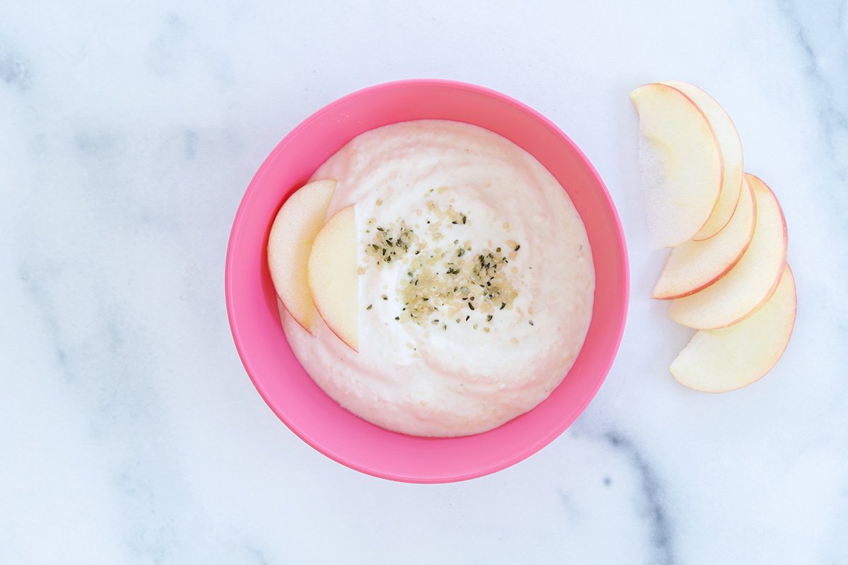applesauce yogurt in pink bowl with apple slices