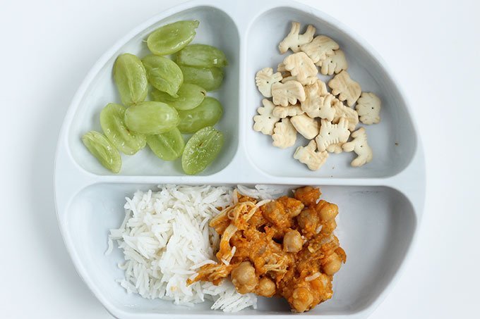 chicken and beans with rice and grapes on kids plate