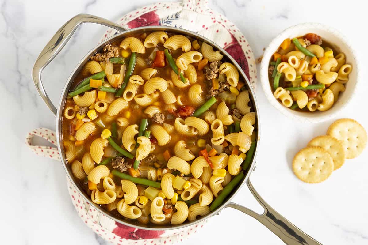 Macaroni soup in pan and bowl.