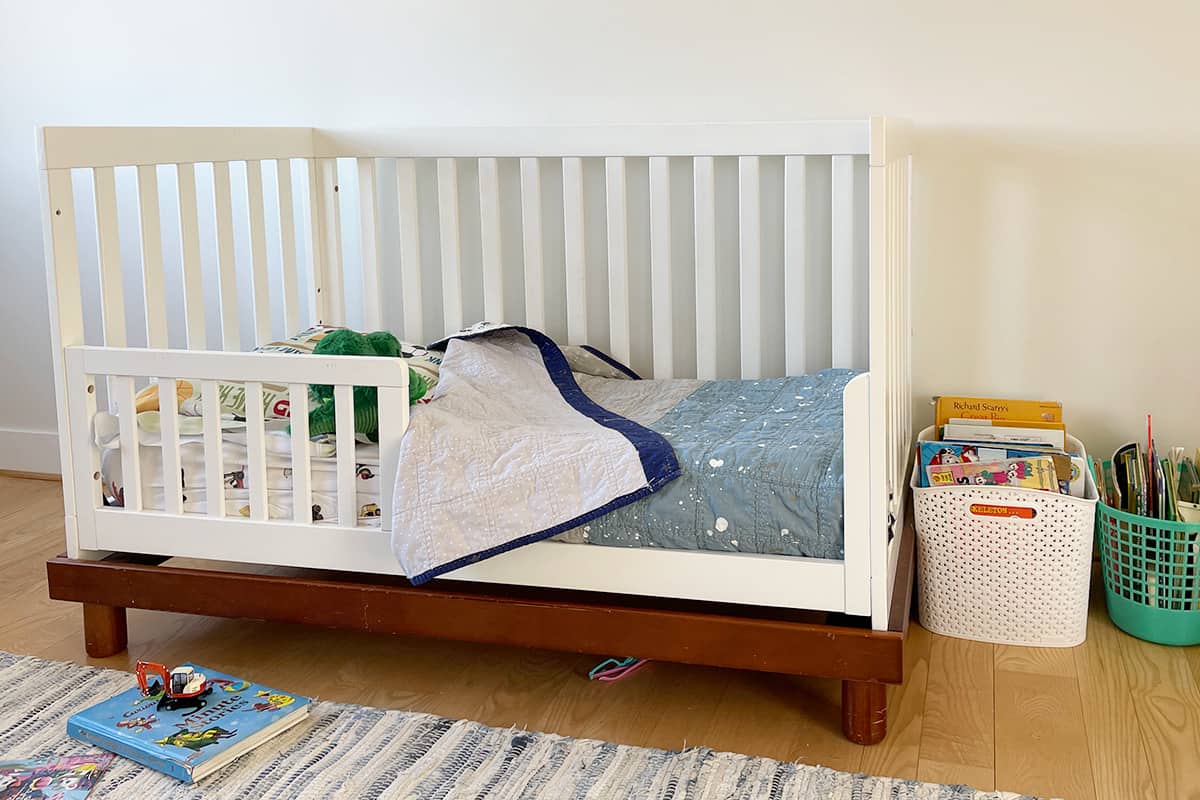 toddler bed with baskets of books.